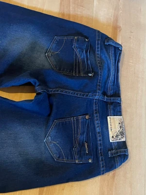 Blå lågmidjade bootcut jeans  - Midjemått: 38 cm. Innebenslängd 78cm. Mörkblå bootcut jeans i fint skick! 