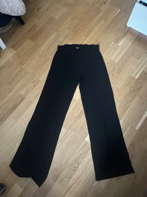Svarta vida leggings - Säljer ett par svarta leggings med breda ben och hög midja. De är stretchiga och mjuka, perfekta för en chill och avslappnad stil. Passar till oversized tröjor eller crop tops för en trendig look.