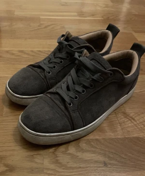 Gråa Louboutin mockaskor med vita sulor - Snygga gråa sneakers i mocka med vita sulor och matchande mörkgrå skosnören. Skorna har en låg profil och diskret design som passar till det mesta. Insidan är ljusbrun och de har dragflik bak för enkel påtagning. Följer med box, dustbag osv. Skickar dagen du köper eller dagen efter beroende på tid! 💨 