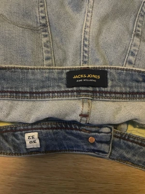 Ljusblå jeans från Jack & Jones - Säljer ett par ljusblå jeans från Jack & Jones med klassisk femficksmodell och raka ben. hover label bak i midjan och sny «Jeans Intelligence»-detalj. Tillverkade i slitstark denim med kontrastsömmar och kopparfärgade_ nitar.