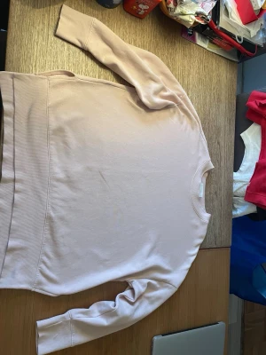 Ljusrosa oversized sweatshirt utan huva från Monki - En stilren ljusrosa oversized sweatshirt i mjukt bomullsmaterial från Monki. Tröjan har rund halsringning, långa ärmar och breda muddar vid ärmslut och nederkant. Perfekt för en avslappnad och enkel look.