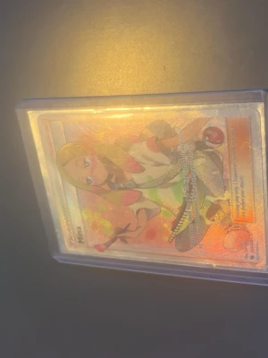 Pokémonkort Mina Trainer Full Art - Säljer ett Pokémonkort med motivet Mina Trainer Full Art. Kortet har holografisk yta med färgglada detaljer och är skyddat i en plastficka. Perfekt för samlare som gillar anime och Pokémon.