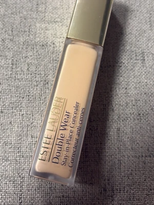 Estée Lauder Double Wear Concealer - Estée Lauder Double Wear Stay-in-Place Concealer i nyansen 3C. Kommer i en rektangulär plasttub med guldfärgat lock. Concealern har en ljus beige ton och är perfekt för att täcka mörka ringar och ojämnheter. Enkel att applicera och ger ett naturligt resultat.