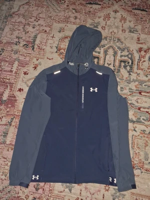 Mörkblå vindjacka från Under Armour - Säljer min mörkblåa jacka pga att den it passade. Perfekt. för sommaren och våren. Pris kan diskuteras såklart❗️❗️❗️