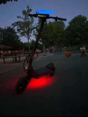 Svart elscooter KuKirin med LED-belysning - Säljer en svart elscooter med robust ram och breda däck. Scootern har LED-belysning undertill som lyser rött och tydliga handtag med display på styret. Märket är KuKirin, vilket syns på dekalerna. Perfekt för dig som vill ta dig fram snabbt och smidigt.