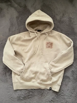 year off the dragon  - Snygg beige hoodie från pull&bear med stor grafisk print på ryggen och mindre tryck på bröstet. Hoodien har klassisk känguruficka, ribbade muddar och dragsko i huvan. Materialet är mjukt och bekvämt, perfekt för en avslappnad look.