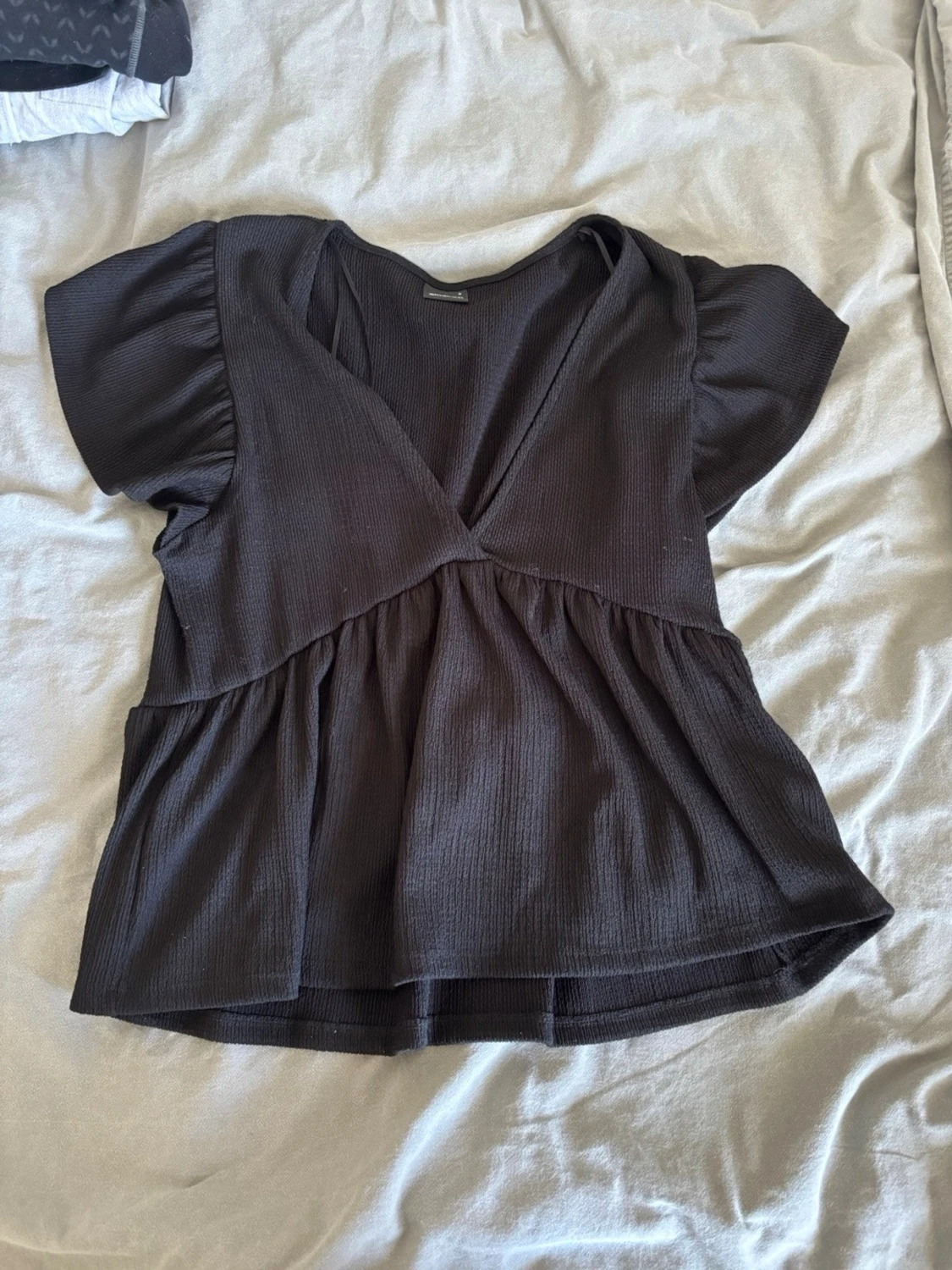 Svart v-ringad blus med volang