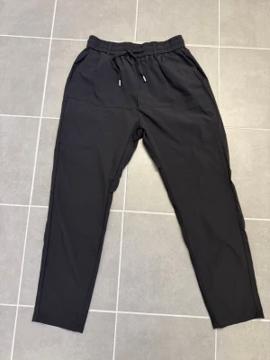 Svarta mjukisbyxor från G-Star RAW stl M - Snygga svarta mjukisbyxor från G-Star RAW med dragsko i midjan och två sidofickor. Byxorna har en avslappnad passform och är tillverkade i ett mjukt material som känns skönt mot huden. Perfekta för chill dagar eller när du vill ha det bekvämt.