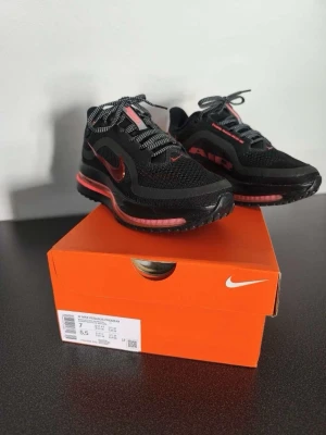 Nike Pegasus Premium svart/röd sneakers - Nike Pegasus Premium sneakers i svart mesh och syntet med röda detaljer. Dom har bara blivit använda 2 gånger och ser fortfarande helt nya ut, originalpriset är 2300 kronor och säljer dom för att dom vart just lite för små för mig. .