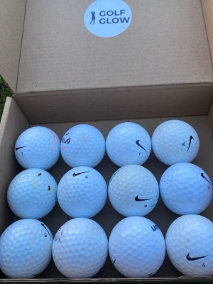 12 vita golfbollar från Nike - Säljer ett set med 12 vita golfbollar från Nike, levereras i en enkel kartong med Golf Glow-märke. Bollarna har klassisk dimple-yta och några har tryck som Mojo och Nike-logga. Perfekt för dig som vill fylla på golfbagen inför säsongen.
