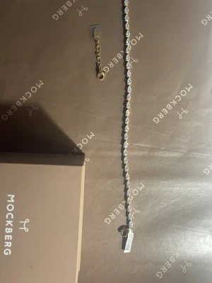 Mockberg tennis armband - Helt nytt och oanvändt tennisarmband från Mockberg med droppformade, glittrande pärlor. Själva armbandet är i guld. Kommer med lådan och silkes påse. Storlek M med justerbar kedja som ger +3cm. Nypris: 799 Pris kan diskuteras🥰