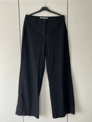 Svarta vida kostymbyxor - Svarta kostymbyxor med hög midja och vida ben från Bershka som knappt använts💕💕