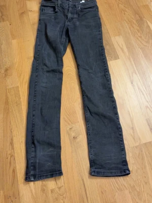Svarta raka jeans från Armani Jeans - Säljer ett par svarta jeans från Armani Jeans med rak passform och klassisk femficksdesign. Jeansen har bälteshällor, dragkedjegylf och är tillverkade i ett mjukt denimtyg. Perfekta för en stilren och avslappnad look.