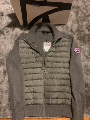 Canada goose cardigan - Säljer en snygg jacka från Canada goose i ny skickt. Säljer då den längre inte passar de där är när jag fick jackan. Den ser exakt likadan ut nu