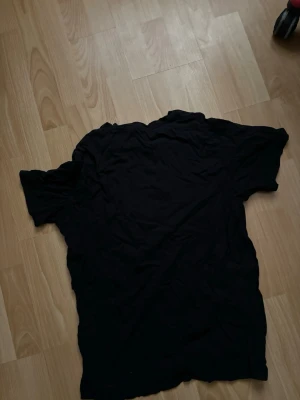 Svart t-shirt med blommigt tryck - Rensar .