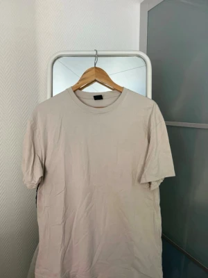 Beige oversized t-shirt från FSBN - Säljer en beige oversized t-shirt från FSBN i storlek S. T-shirten har rund halsringning och korta ärmar. Tillverkad i mjukt bomullsmaterial som känns skönt mot huden. Enkel och clean design som passar till det mesta.