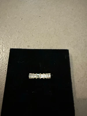 Silverring med rektangulära stenar - Snygg silverring med flera rektangulära, klara stenar i rad. Ringen har en modern och stilren design med stenar som är infattade i en klassisk fattning. Perfekt för dig som gillar minimalistiska smycken med lite extra glans.