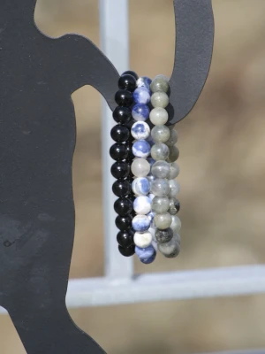 Naturstensarmband 3x bundle - Säljer ett set med pärlarmband i svart, blått, vitt och grått. Armbanden består av runda pärlor i stenliknande material och kan bäras tillsammans eller separat. Perfekt som accessoar till jeans och t-shirt.