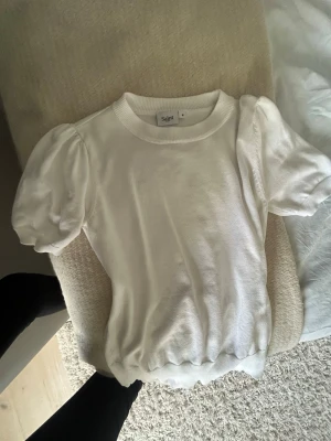 Vit topp med puff ärm - Det är en söt vit topp som man kan styla på många olika sätt och tillfällen. Den är krit vit, och inte använd så mycket. 