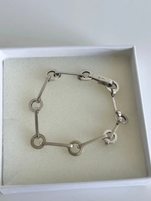Efva attling Silverfärgat armband med cirkellänkar - Original pris 3000 och aldrig använt. Stilrent armband från Efva Attling, i silverfärgad metall med raka stavar och runda cirkellänkar. Modern och minimalistisk design som ger en cool touch till din outfit. Perfekt för dig som gillar enkla men unika accessoarer.