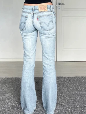 Ljusblå bootcut jeans från Levi's - Säljer ett par ljusblå vintage bootcut jeans från Levi's med klassisk femficksdesign och låg midja.