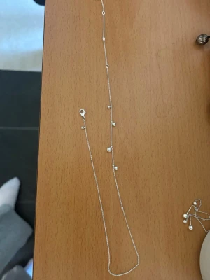 Silverfärgat armband/fotlänk  Pilgrim - Snyggt och stilrent smycke som kan användas som både armband och fotlänk från Pilgrim i silverfärg. Perfekt för dig som gillar minimalistiska smycken med en twist. Märkt med Pilgrim-tag vid låset.