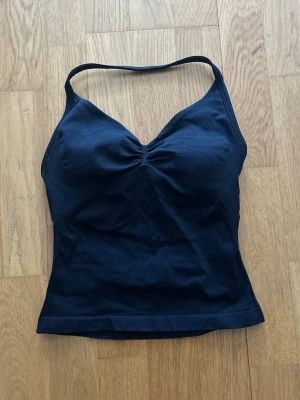 DFYNE Impact Longline Strappy Top - Säljer en DFYNE Impact Longline Strappy Top i färgen ”Midnight Black” med inbyggd sport-bh i st XS, endast använd fåtal gånger hemma då den är för liten vid brösten. Original pris 52,95€ - ca 580kr. Finns orderbekräftelse och DFYNE-tag bak om man vill se för äkthets bevis!!