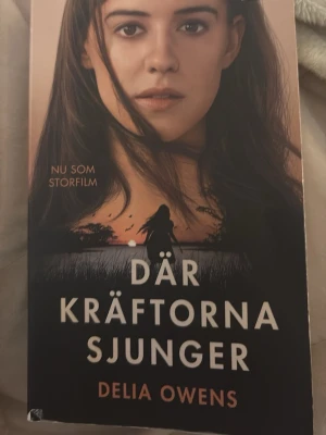 Där kräftorna sjunger pocket - Säljer pocketutgåvan av 'Där kräftorna sjunger' av Delia Owens. Omslaget har en bild från filmatiseringen med en kvinna i förgrunden och naturmotiv i bakgrunden. Boken är på svenska och har mjuka pärmar i beige och svart ton.