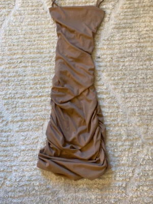 Scrunched up klänning - Jag säljer denna fina klänning då jag inte tycker den passar som den ska på mig ❤️ klänningen är scrunched det är därför den ligger som den gör på bilderna men skriv gärna för mer info om du undrar något ❤️(klänningen är beige/ brun) 