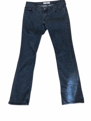 Utsvängda lågmidjade jeans  - Säljer ett par snygga och trendiga lågmidjade bootcut-jeans från Fornarina i storlek S/36. Jeansen har en smickrande passform med utsvängda ben och den klassiska Y2K-stilen som är populär igen.  ✔️ Märke: Fornarina ✔️ Storlek: S / 36 ✔️ Färg: Svart/grå denim ✔️ Skick: Mycket bra ✔️ Innerbenslängd: ca 80 cm  Jeansen sitter lågt i midjan och passar ungefär XS–S beroende på önskad passform. Perfekta att matcha med en topp, hoodie eller kavaj för en snygg vardagslook.  Det finns en liten defekt på ena ba