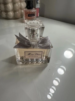 Miss Dior Eau de Parfum 50ml - Miss Dior Eau de Parfum från Dior i en elegant, rektangulär glasflaska med en ljusrosa doftvätska. Den är i 30ml och är använd endast en gång. Piset kan alltid diskuteras💕