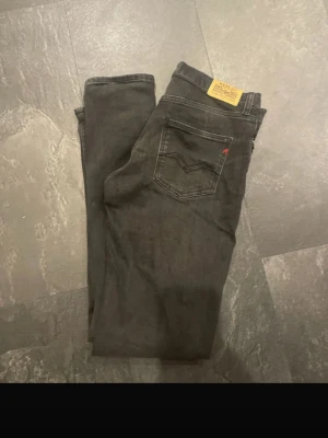Svarta jeans från Replay - Snygga svarta jeans från Replay med klassisk femficksmodell och diskret Replay-logga på bakfickan. Jeansen har raka ben och är tillverkade i ett mjukt denimtyg som ger en skön passform. Perfekta för dig som gillar stilrena och tidlösa plagg.