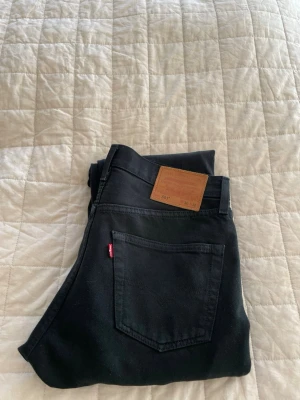 Svarta Levi's 501 jeans - Klassiska svarta Levi's 501 jeans. Väldigt slitstarkt material. Byxorna är omsydda av proffesionella vilket gör storleken till W30 och L30.