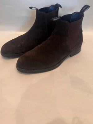 MAC. Fincher - Säljer ett par exklusiva Mac Fincher boots i mycket fint skick. Stilrena och tidlösa skor i mörkbrunt läder/mocka som passar perfekt både till vardag och mer uppklädda tillfällen.  Skorna är sparsamt använda och väl omhändertagna. Bekväma med bra passform och hög kvalitet i material och finish.  Kvitta, låda och bag medkommer. Tveka inte att kontakta vid fler bilder eller funderingar!