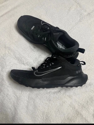 Nike Juniper Trail 2 Gore Tex (Vattentäta) Stl 38,5 – Toppskick! - Säljer ett par Nike Juniper Trail 2 i herre/unisex-modell (storlek 38,5) utrustade med GORE-TEX, vilket gör dem helt vattentäta men samtidigt ventilerande. Skorna är i mycket gott skick (se bilder på innersula och tåparti för bekräftelse på sparsam användning). De är perfekta för dig som vill kunna springa eller gå på skogstigar och asfalterade vägar oavsett väder utan att bli blöt om fötterna. Egenskaper: • Vattentäthet: GORE-TEX-membran håller fötterna torra i regn och slask. • Grepp: Robust y