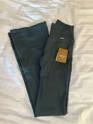 Mörkgröna ribbade leggings Aim'n - Mörkgröna ribbade leggings från amin med utsvängda ben. Oanvända.