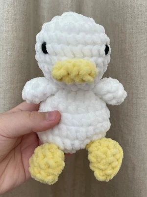 Virkad anka i vitt – handgjord plushie - Handvirkad anka i mjukt chenillegarn i vitt med gula detaljer. Supermjuk och perfekt som dekoration eller present. Varje anka är unik och gjord för hand. Storlek: ca 15 cm.