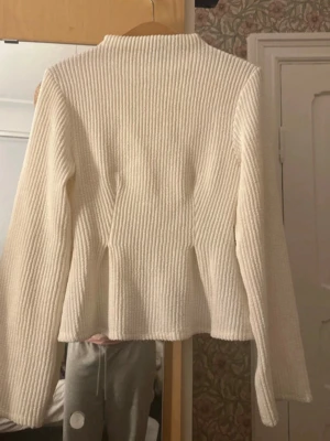 Vit ribbstickad tröja Gina Tricot - Säljer en vit ribbstickad tröja från Gina Tricot. Tröjan har lång ärm, rak passform och hög hals. Perfekt för lager-på-lager och enkel att matcha med olika outfits. Materialet är mjukt och ger en stilren look. Finns en liten fläck(se bild 3). Kommer inte till andvändning.