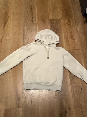 Beige hoodie med tryck från Mackage - Beige hoodie från Mackage med stor huva och tryck på utsidan av huvan. Passar s och m
