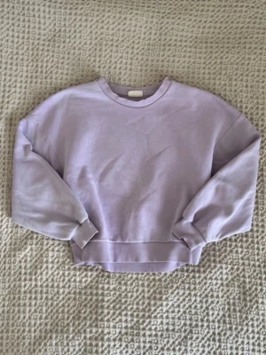 Ljuslila sweatshirt - Stilren ljuslila sweatshirt med o-neck och ribbade muddar. Tröjan tillverkad i mjukt bomullsmaterial. Enkel, clean look utan tryck eller detaljer. Perfekt för en avslappnad och trendig stil.