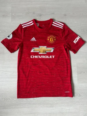 Manchester United tröja - Säljer en snygg och stilren Manchester United-tröja i fint skick – perfekt för både matchdagar och vardagsstil! 🔴⚽ Tröjan är bekväm, av hög kvalitet och ett måste för alla fans av klubben.  Storlek 15/16yr men sitter som S  Passa på att uppdatera din supporter-garderob eller ge bort en uppskattad present till någon som älskar fotboll!  👉 Kika gärna in min profil – jag säljer fler fotbollströjor i olika modeller och storlekar. 💥 Rabatt erbjuds vid köp av flera plagg!  Hör av dig vid frågor!