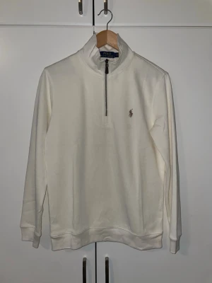 Beige half-zip tröja Polo Ralph Lauren - Beige långärmad tröja från Polo Ralph Lauren med half-zip och hög krage. 