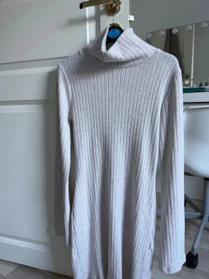 Beige poloklänning - Säljer en beige klänning från Gina tricot i storlek S. Klänningen har ett jack vid den nedre delen och har en hög krage. Det är lite tjockare material så man kan ha på sig den oavsett väder. Den har bara använts en gång så den är i superbra skick som ny.