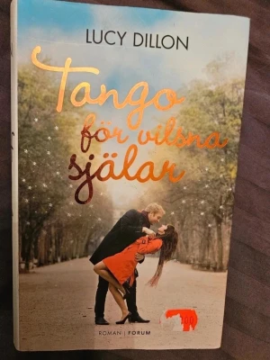 Tango för vilsna själar - Romanen 'Tango för vilsna själar' av Lucy Dillon har ett färgstarkt omslag med ett dansande par i höstiga toner. Boken är i pocketformat med mjukt omslag och glittrande text. Perfekt för dig som gillar romantik och känslor