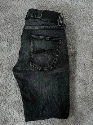 Nudie jeans grim Tim  - Säljer ett par nudie jeans i storlek 30/34 grim Tim i färgen black pixel. Nypris - 1699kr säljs - 799kr! Vid minsta fundering bara att höra av sig!☑️