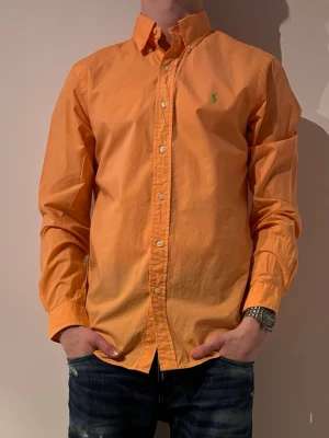 Orange skjorta från Ralph Lauren - Storlek M men passar S modellen är 180 och väger 70💯✌️ hör av er vid minsta fråga eller fundering😊✌️(liten defekt på lappen men 100% äkta köpt från Sellpy)