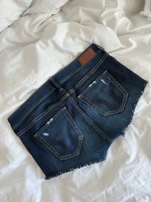 Mörkblå jeansshorts från Hollister - Jeansshorts från Hollister!!Se midjemått på bilderna💕 W26