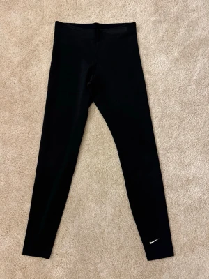 Svarta tights från Nike  - Svarta snygga tights från Nike, perfekt till både träning och för att chilla. (Tyg material och inte vanligt träningsmatrial) 