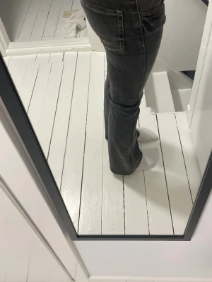 Grå bootcut jeans med stretch - Säljer ett par grå bootcut jeans med snygg tvätt och klassiska fem fickor. Jeansen har en figurnära passform upptill och utsvängda ben. Tillverkade i stretchigt denimtyg för extra komfort. Perfekta för en trendig och avslappnad look.