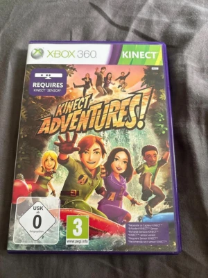 Kinect Adventures till Xbox 360 - Kinect Adventures är ett actionfyllt spel till Xbox 360 som kräver Kinect-sensor. Omslaget är färgglatt med karaktärer i äventyrsmiljö, och spelet levereras i en klassisk plastfodral med lila kant. Perfekt för dig som gillar rörelsebaserade spel.